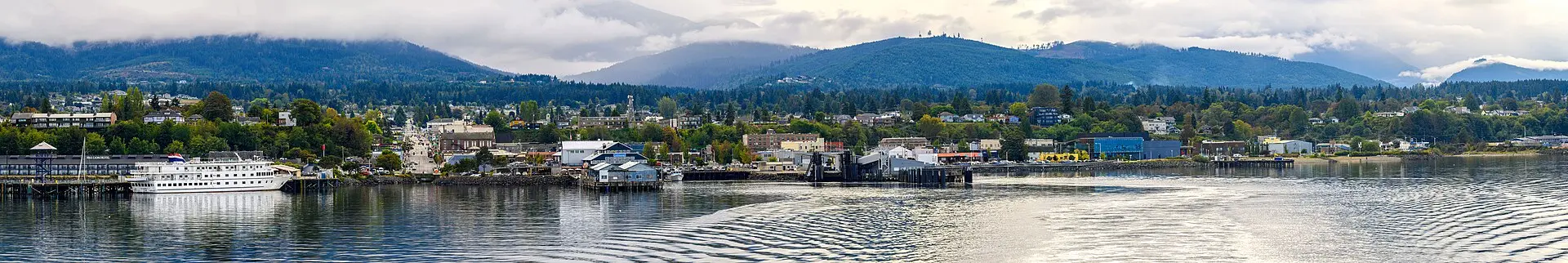 Wide view of the Port Angeles, Washington waterfront and harbor, with the Olympic Mountains rising behind the town